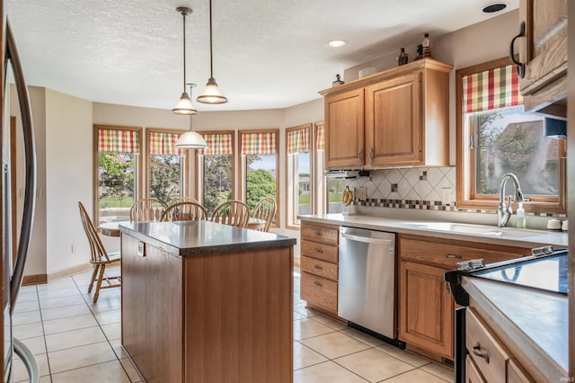 9725 Sea View Cv, Fort Wayne, IN 46835 - kitchen with appliances with stainless steel finishes, a sink, a center island, backsplash, and light tile patterned flooring