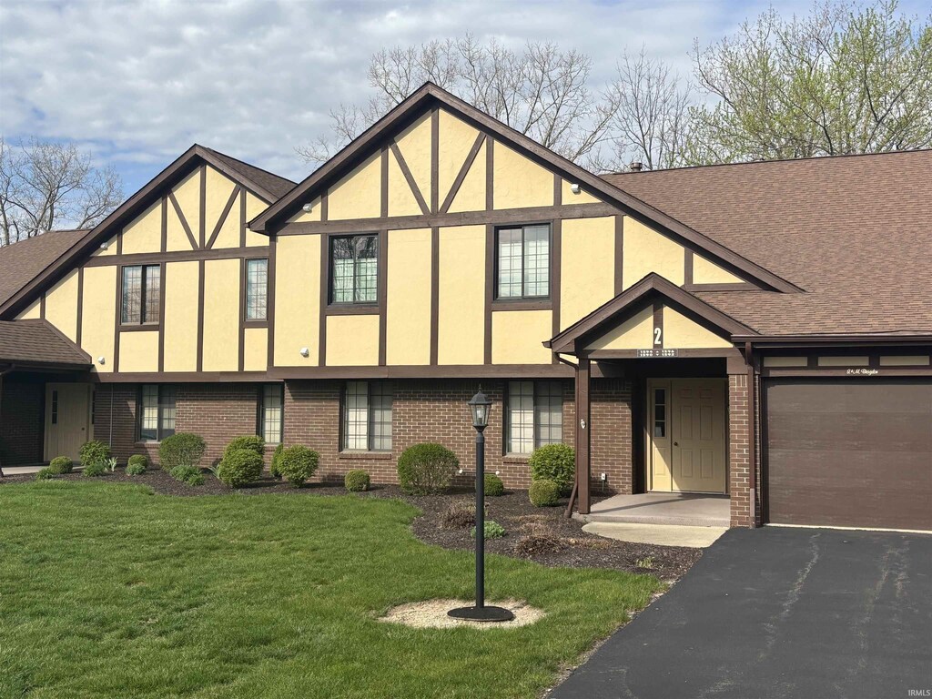 1594 William Wells Cir, Bluffton, IN 46714 - tudor house with brick siding, driveway, stucco siding, and a front yard