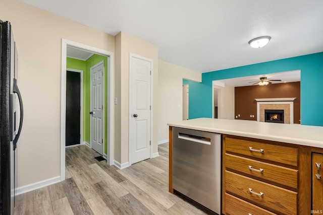 kitchen featuring dishwasher, a ceiling fan, brown cabinets, freestanding refrigerator, and light countertops