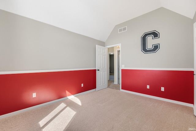 unfurnished bedroom with lofted ceiling, carpet, and baseboards