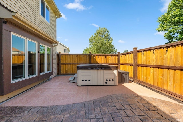 view of patio / terrace with a hot tub and a fenced backyard