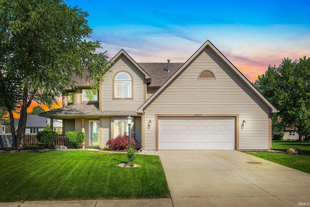 traditional-style house with a yard, driveway, an attached garage, and a shingled roof