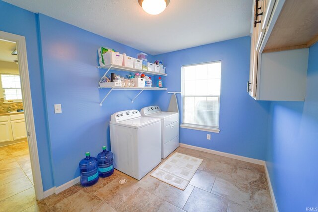 2027 Wesmar Ct, Kokomo, IN 46902 - clothes washing area with washing machine and dryer, plenty of natural light, cabinet space, and baseboards