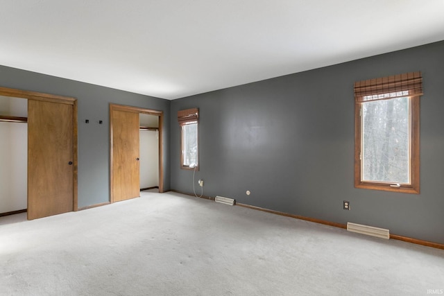 52022 Old Post Ln, Granger, IN 46530 - unfurnished bedroom featuring two closets, light colored carpet, and baseboards