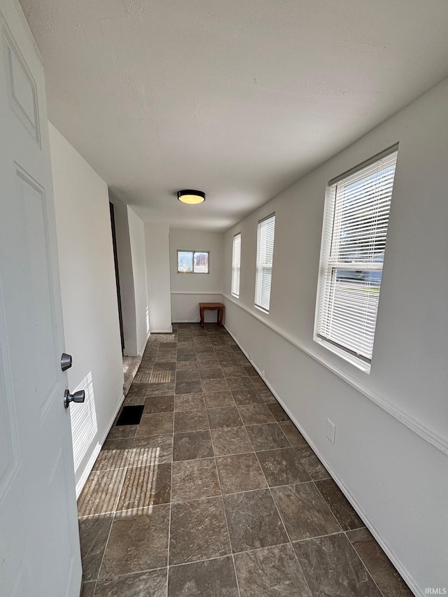 721 S Hackley St, Muncie, IN 47302 - empty room featuring stone finish floors, baseboards, and a textured ceiling