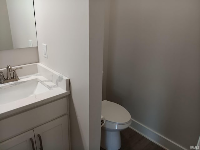 224 E 6th Ave, Ingalls, IN 46048 - half bath featuring vanity, toilet, wood finished floors, and baseboards