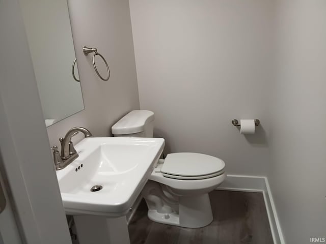 224 E 6th Ave, Ingalls, IN 46048 - bathroom with toilet, a sink, baseboards, and wood finished floors