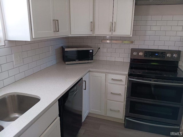 224 E 6th Ave, Ingalls, IN 46048 - kitchen with double oven range, dishwasher, white cabinetry, wood finished floors, and backsplash