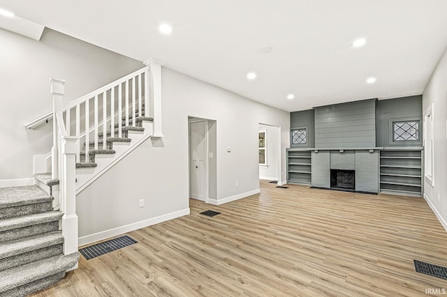 209 Marquette Ave, South Bend, IN 46617 - unfurnished living room featuring light wood-type flooring, recessed lighting, stairs, baseboards, and a fireplace