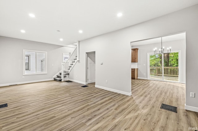 209 Marquette Ave, South Bend, IN 46617 - unfurnished living room featuring light wood finished floors, recessed lighting, baseboards, stairs, and a chandelier