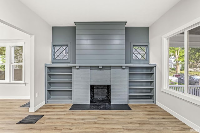 209 Marquette Ave, South Bend, IN 46617 - unfurnished living room featuring wood finished floors, baseboards, plenty of natural light, and a fireplace with flush hearth