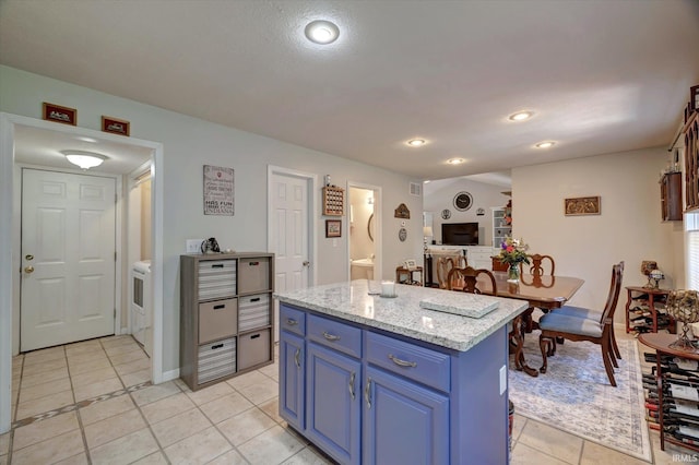 1177 E Marigold Dr, Bloomington, IN 47401 - kitchen featuring blue cabinets, light tile patterned floors, a kitchen island, recessed lighting, and light stone countertops