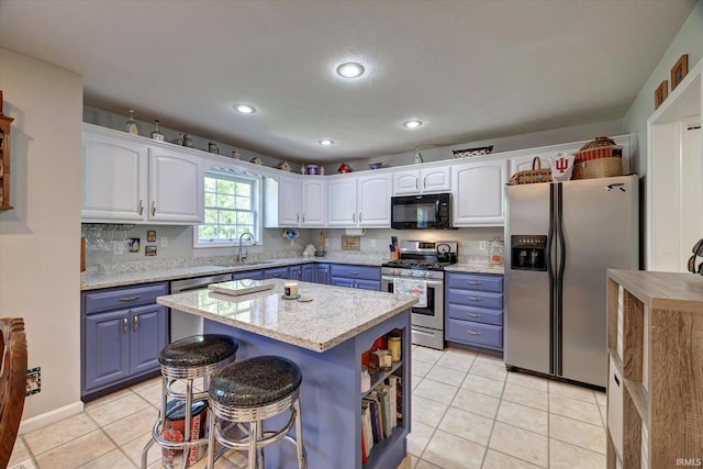 1177 E Marigold Dr, Bloomington, IN 47401 - kitchen with stainless steel appliances, blue cabinetry, a sink, white cabinetry, and recessed lighting