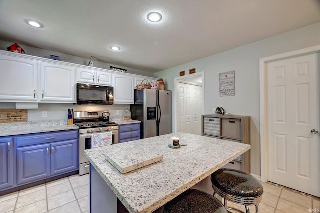 1177 E Marigold Dr, Bloomington, IN 47401 - kitchen featuring stainless steel appliances, blue cabinetry, light tile patterned flooring, a breakfast bar area, and recessed lighting