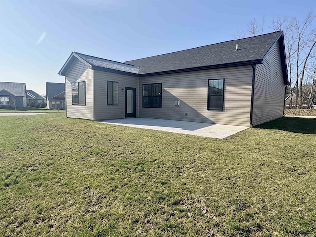 back of property featuring a patio, a yard, and roof with shingles