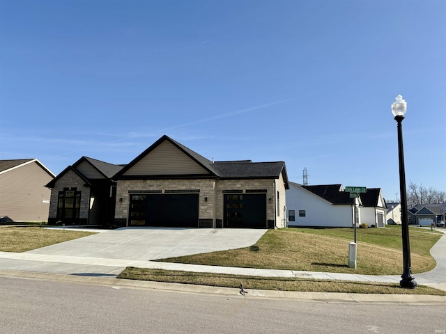 view of front of house with an attached garage, concrete driveway, a front lawn, and stone siding