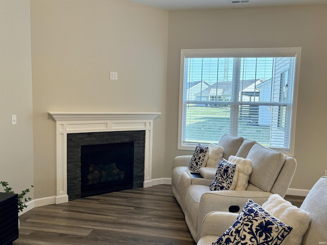 living area featuring dark wood finished floors, a fireplace, and baseboards