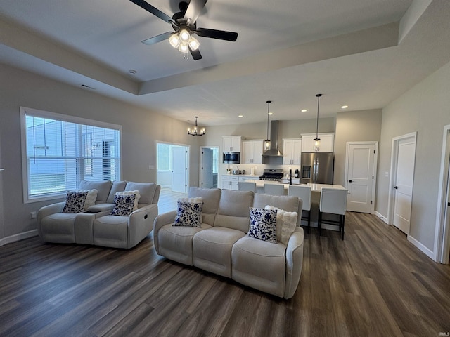 living area with dark wood-type flooring, recessed lighting, baseboards, ceiling fan, and a chandelier
