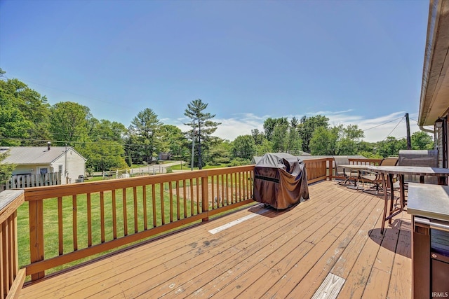 4110 E 10th St, Bloomington, IN 47408 - deck with outdoor dining area, area for grilling, and view of wooded area