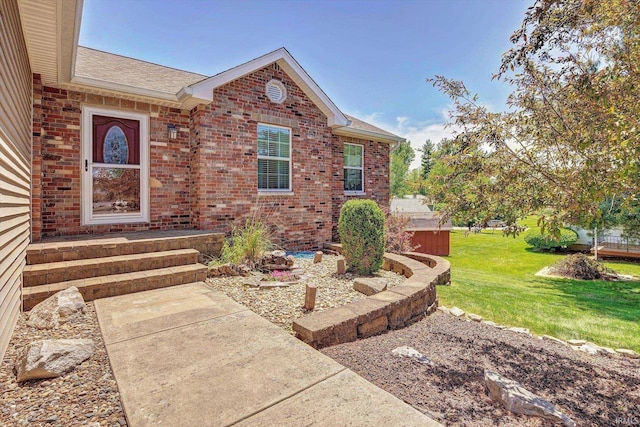 4110 E 10th St, Bloomington, IN 47408 - property entrance featuring brick siding, a yard, and a shingled roof