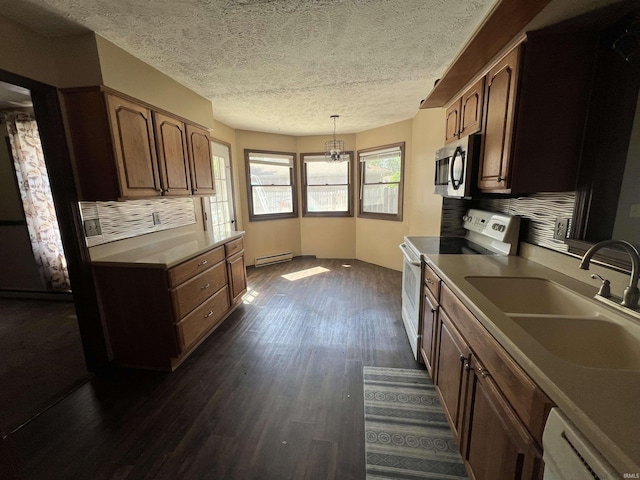 3613 Robin Dr, Kokomo, IN 46902 - kitchen with white range with electric cooktop, stainless steel microwave, a baseboard heating unit, dark wood finished floors, and a sink