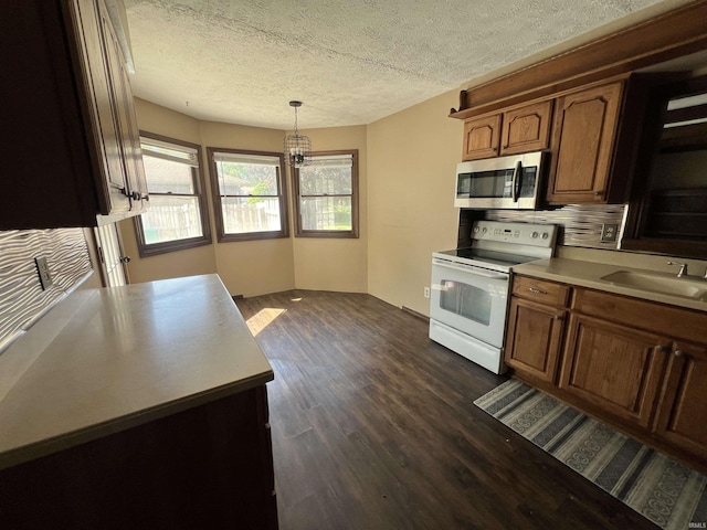3613 Robin Dr, Kokomo, IN 46902 - kitchen with stainless steel microwave, electric stove, a sink, light countertops, and dark wood-style floors