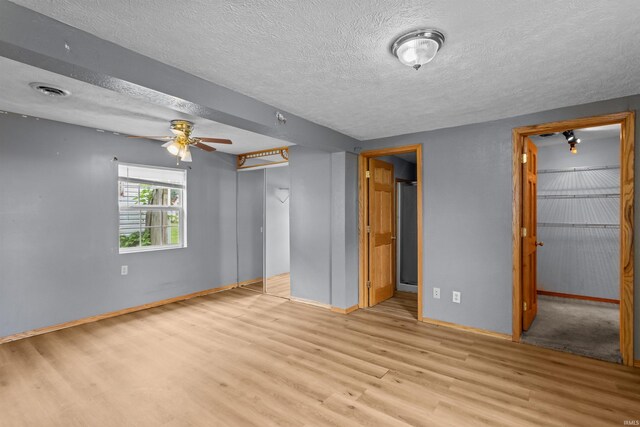 1227 S Main St, Kokomo, IN 46902 - unfurnished bedroom featuring a closet, wood finished floors, baseboards, a textured ceiling, and a ceiling fan