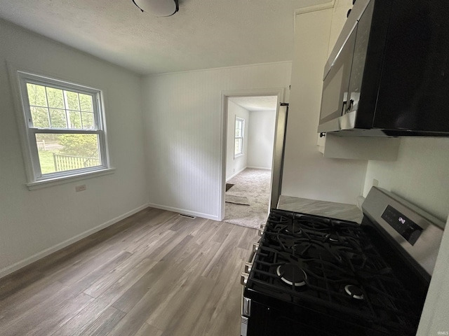 3534 Oakcrest Dr, South Bend, IN 46615 - kitchen featuring stainless steel gas range oven, light wood-type flooring, plenty of natural light, baseboards, and a textured ceiling
