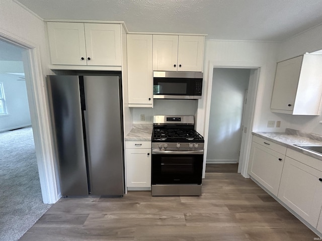 3534 Oakcrest Dr, South Bend, IN 46615 - kitchen featuring stainless steel appliances, white cabinets, and light wood finished floors