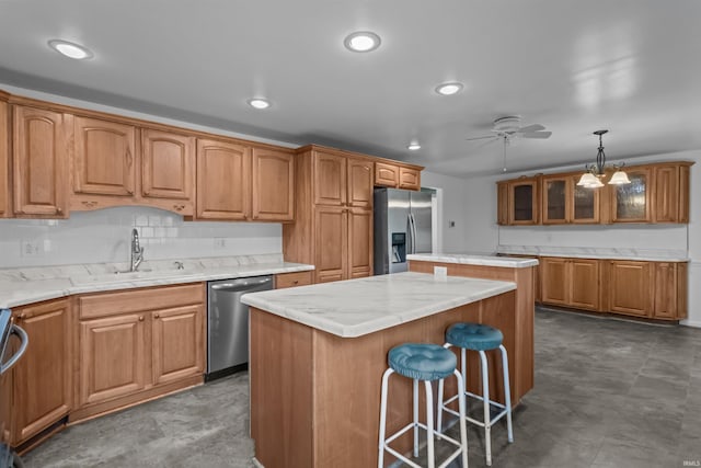 kitchen featuring stainless steel appliances, a sink, a kitchen island, ceiling fan, and glass insert cabinets