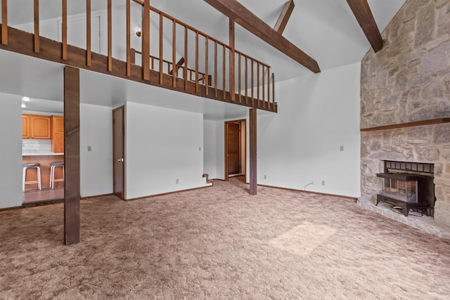 unfurnished living room featuring high vaulted ceiling, carpet, beam ceiling, and baseboards