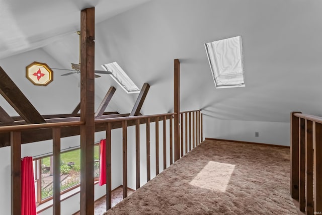 additional living space featuring a skylight, vaulted ceiling, a ceiling fan, and carpet