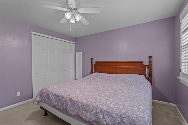carpeted bedroom with a closet, baseboards, and a ceiling fan