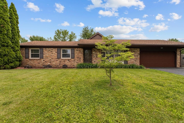 ranch-style home featuring brick siding, asphalt driveway, a front yard, and a garage