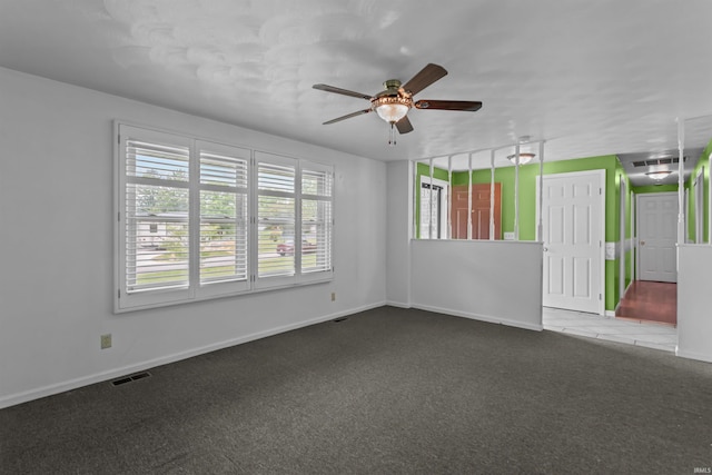 carpeted empty room featuring ceiling fan and baseboards