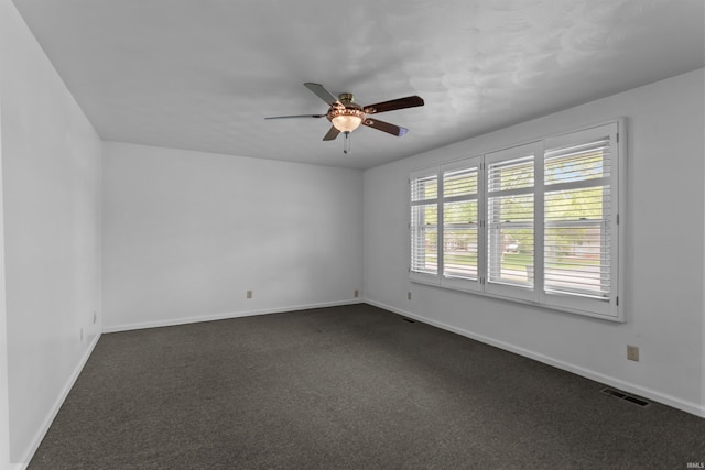 empty room featuring a ceiling fan, baseboards, and dark colored carpet