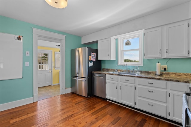 kitchen featuring a sink, appliances with stainless steel finishes, white cabinetry, and healthy amount of natural light