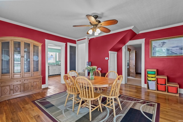 dining area with wood-type flooring, ceiling fan, and crown molding