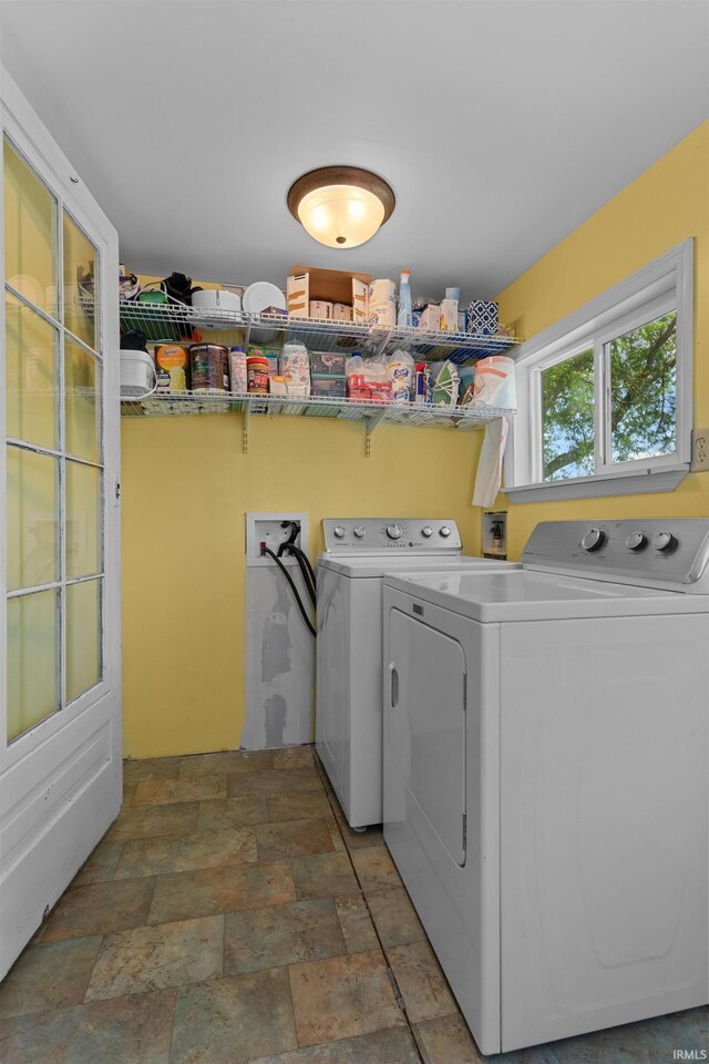 laundry room featuring washer and clothes dryer and stone finish flooring