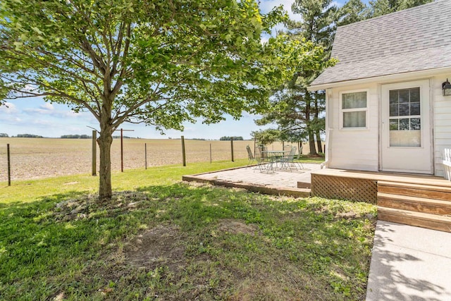 view of yard with a rural view and a patio area