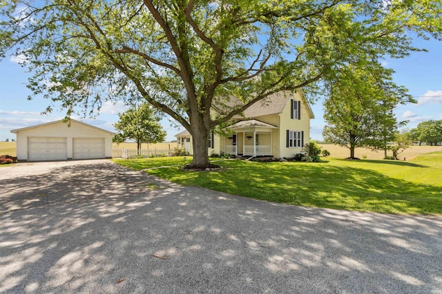 view of front of house with a garage and an outbuilding