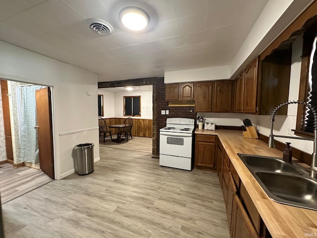 7831 S State Road 19, Peru, IN 46970 - kitchen with electric range, wooden counters, a sink, light wood-style floors, and under cabinet range hood