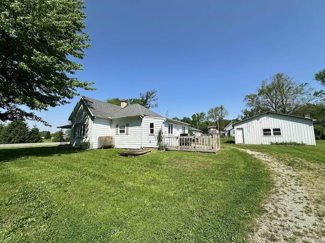 7831 S State Road 19, Peru, IN 46970 - back of house with a chimney, a lawn, heating fuel, a wooden deck, and an outbuilding