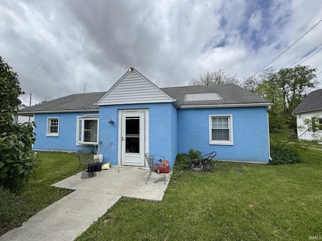 9615 S Olive St, Muncie, IN 47302 - rear view of house featuring concrete block siding, a yard, and a patio