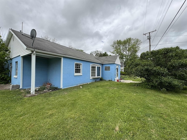 9615 S Olive St, Muncie, IN 47302 - back of property featuring concrete block siding, a yard, and a shingled roof
