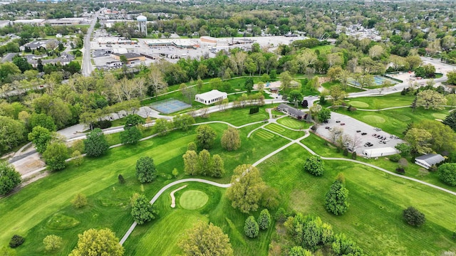 view of property location with a golf course and a tree filled landscape