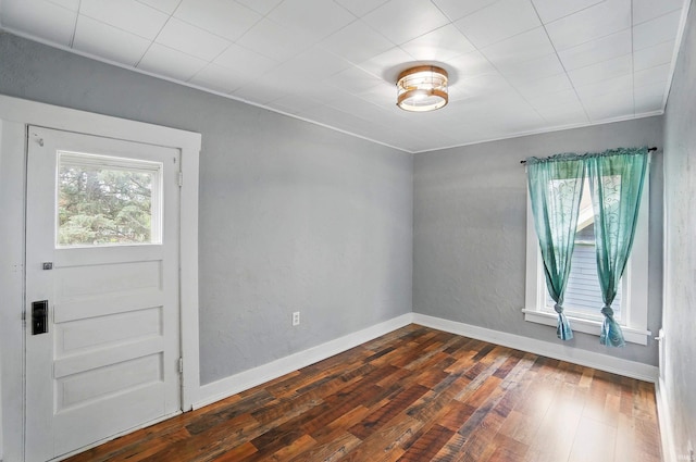 empty room featuring dark wood finished floors and baseboards