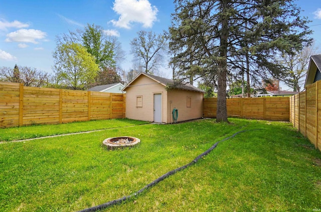 view of yard featuring a fire pit, an outbuilding, and a shed