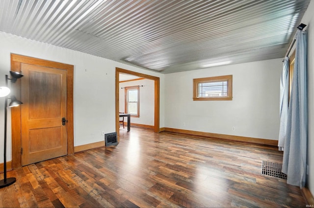 spare room featuring dark wood finished floors and baseboards