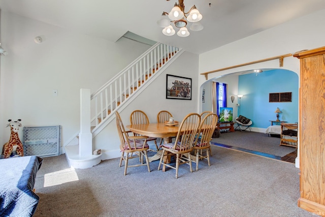 121 Diehl St, Tipton, IN 46072 - carpeted dining area with arched walkways, stairway, and a chandelier